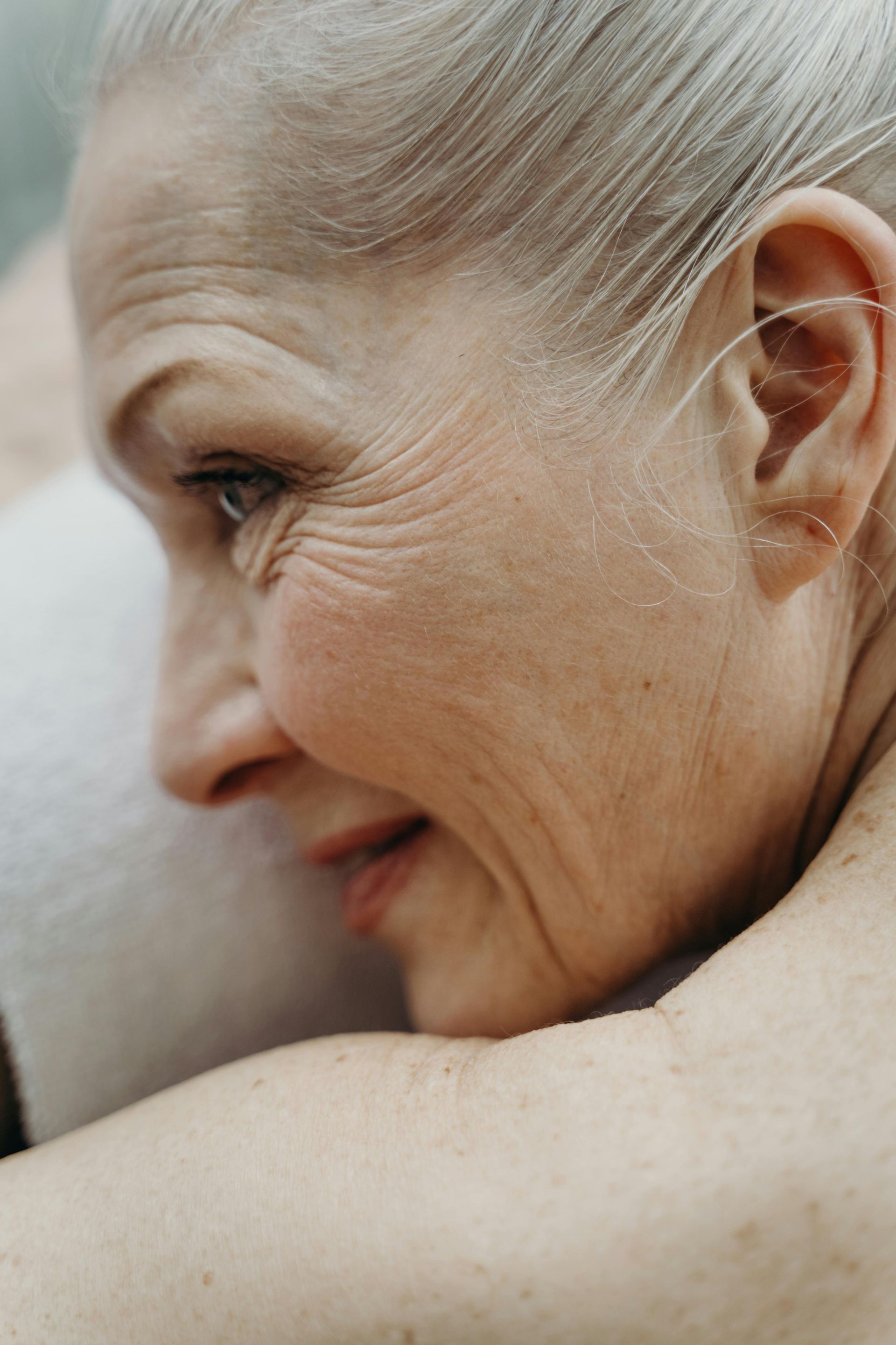 A close up of an older woman 's face and shoulder.