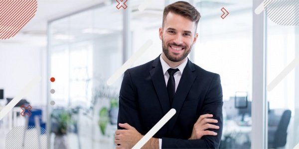 A man in a suit and tie is holding a piece of paper in an office.