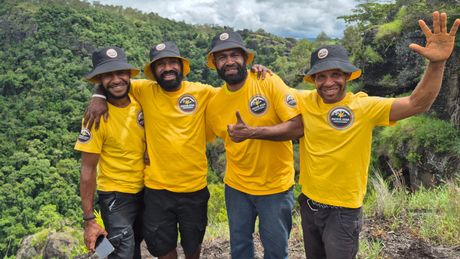 Five people standing in group and smiling at camera on the Kokoda trail  in Papua New Guinea