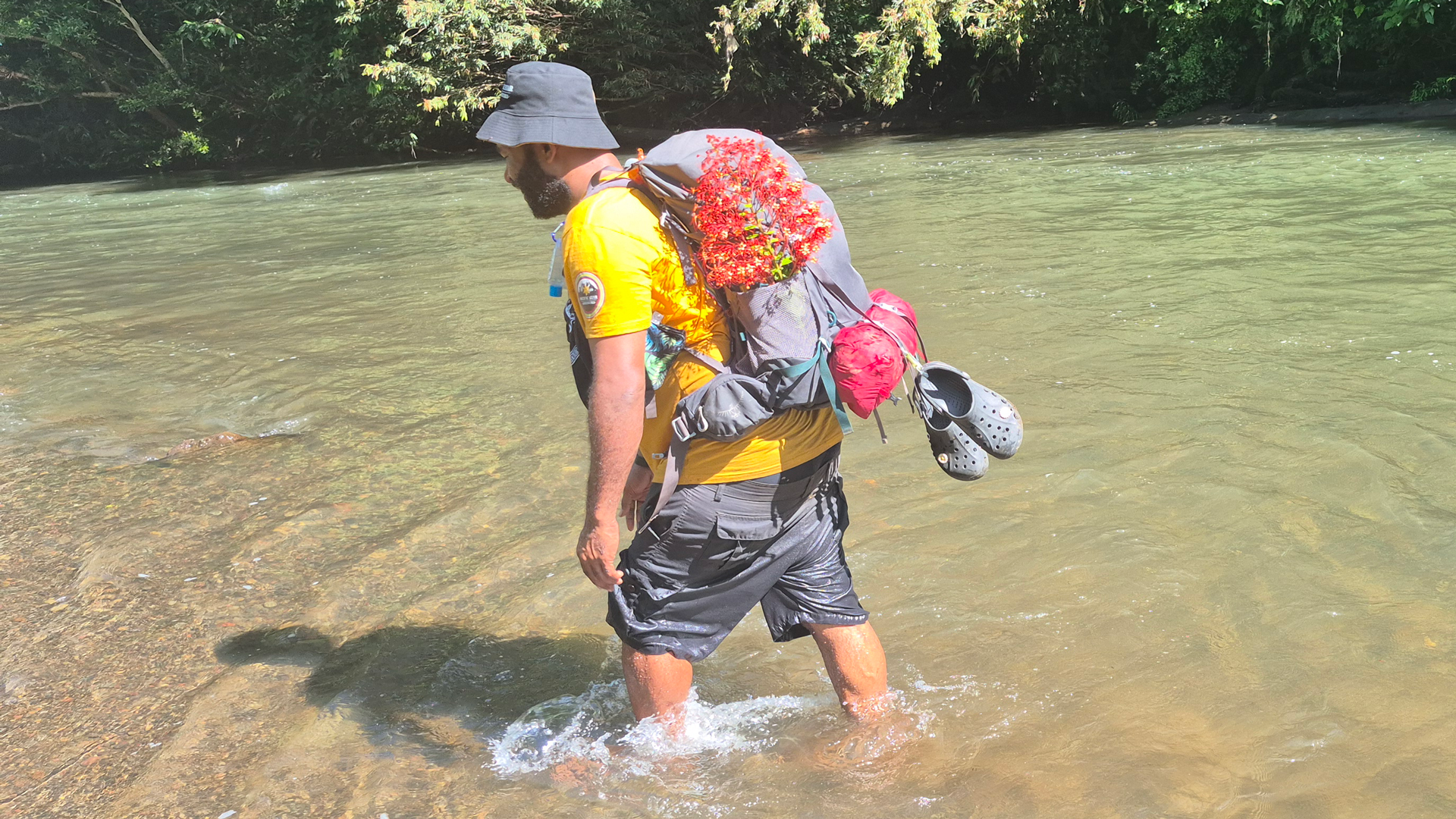 Person waking through a river on the Kokoda trail in Papua New Guinea