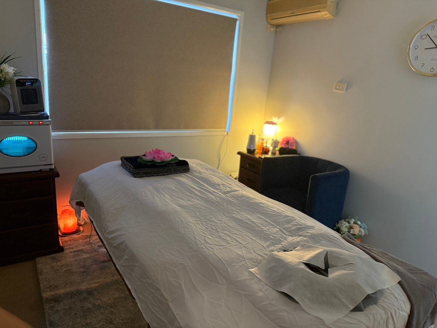 A massage table is sitting in a room next to a window at Sarah's Thai Massage Paradise Point.