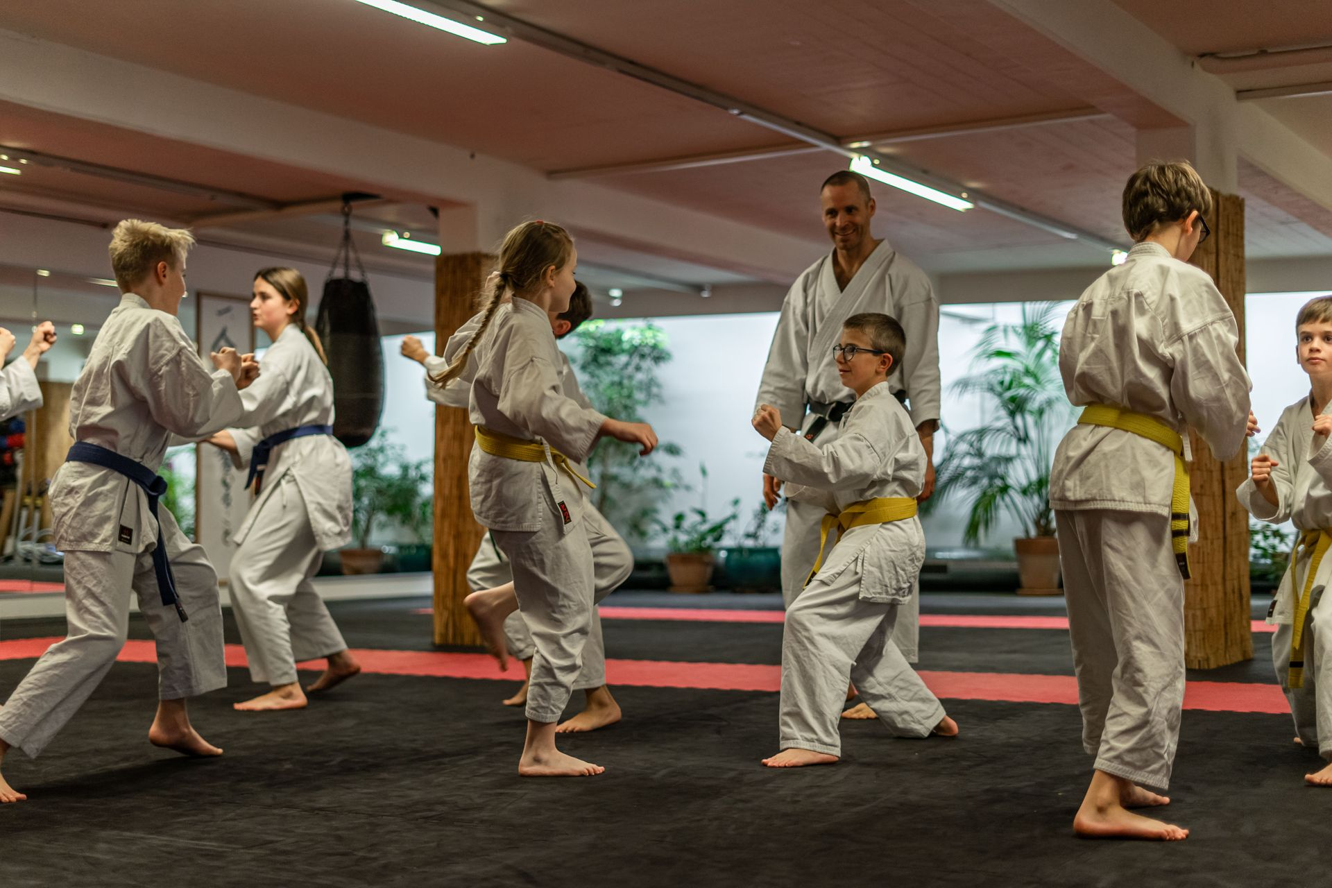 Lächelnder Karatelehrer beobachtet seine Karate-Schüler.
