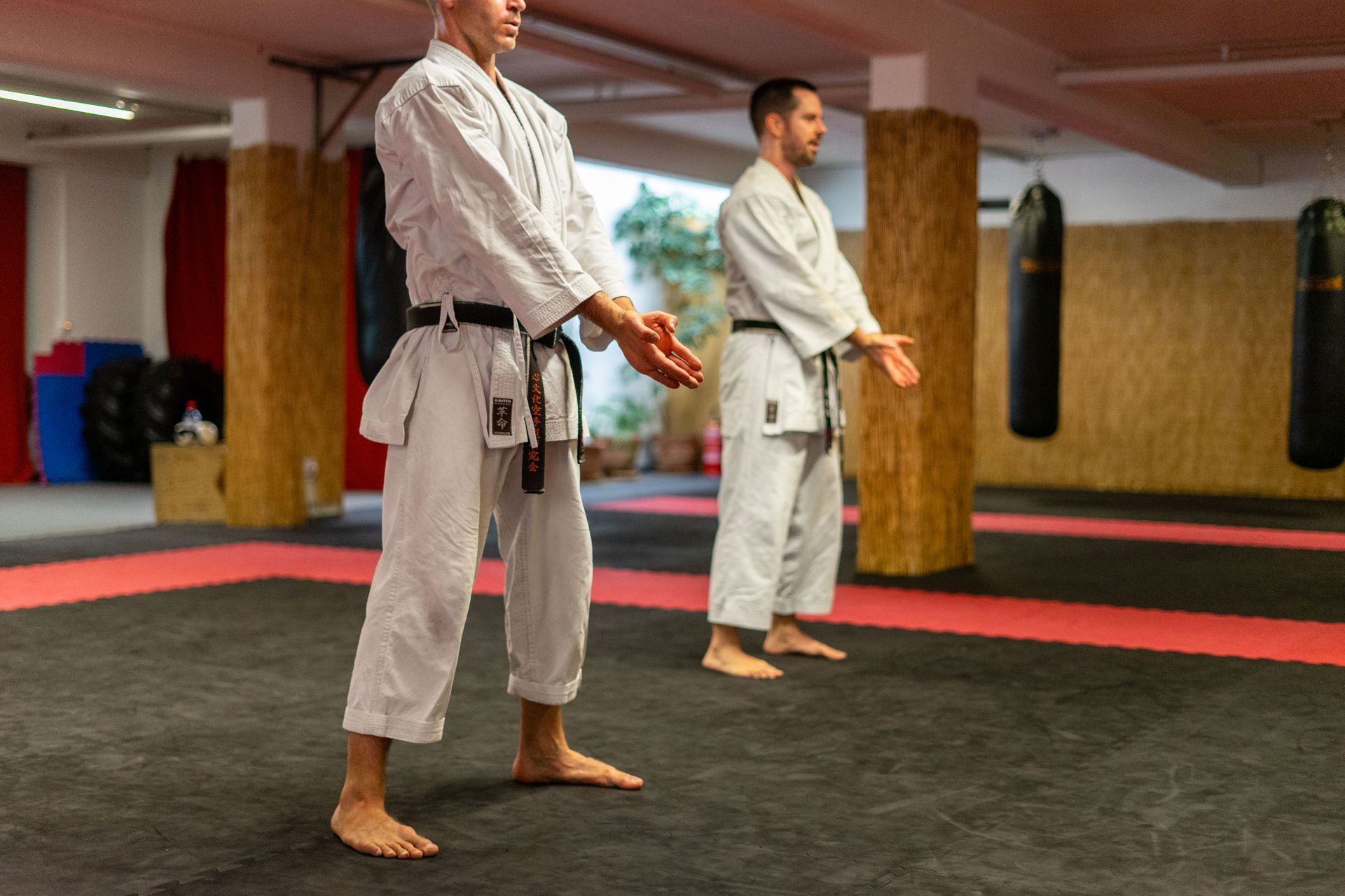 Erwachsene Schwarzgürtel der Karateschule Thun und Spiez stehen in Bereitschafthaltung.