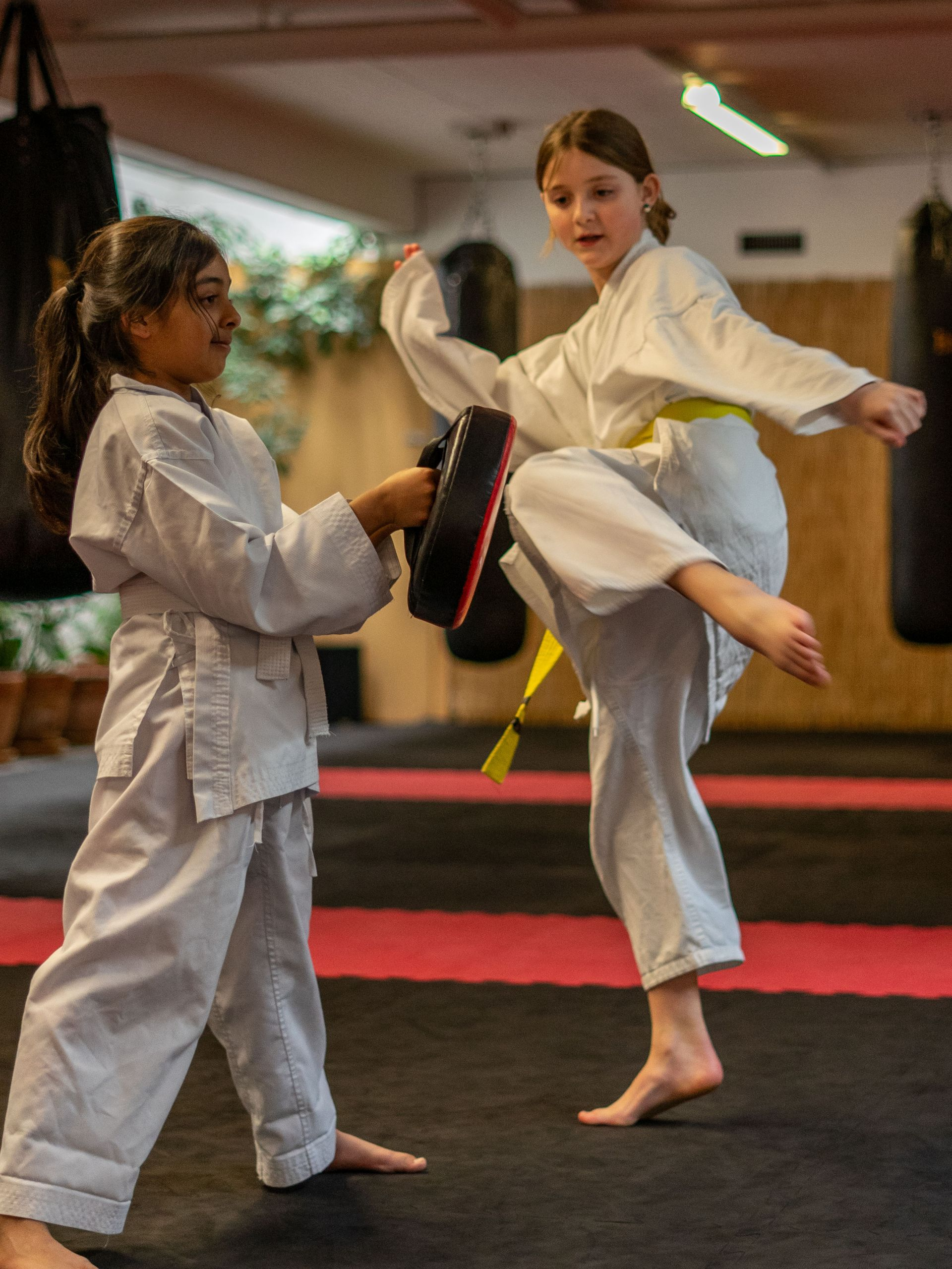 Zwei Mädchen üben Schlagkrafttraining Roundhousekick