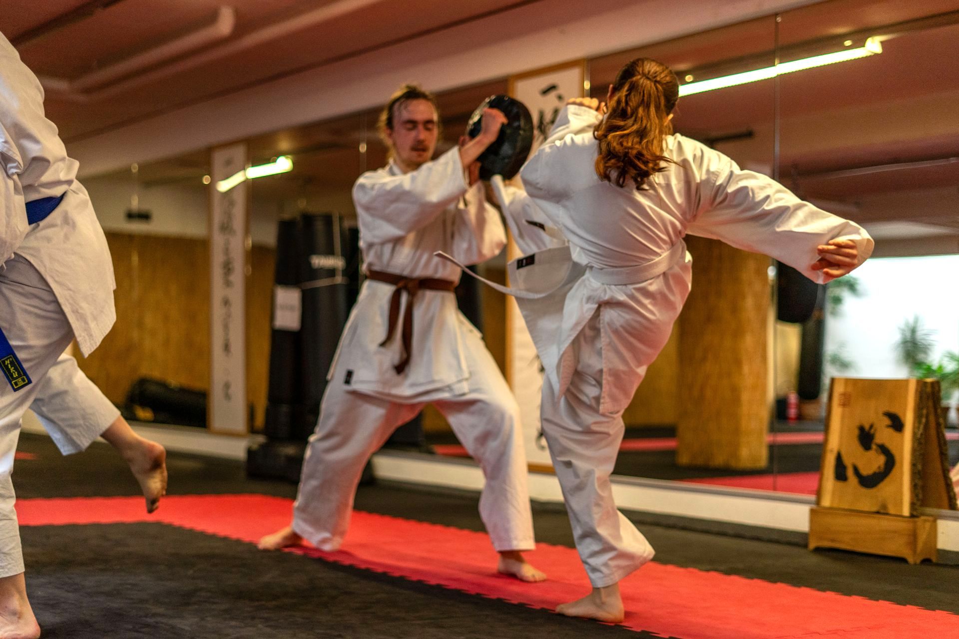 Karateka schlägt kraftvoll auf ein Schlagpolster, um Durchschlagskraft und Explosivität zu trainieren. Fähigkeiten die auch in Kampfsportarten wie BJJ und Kickboxen zentral sind.