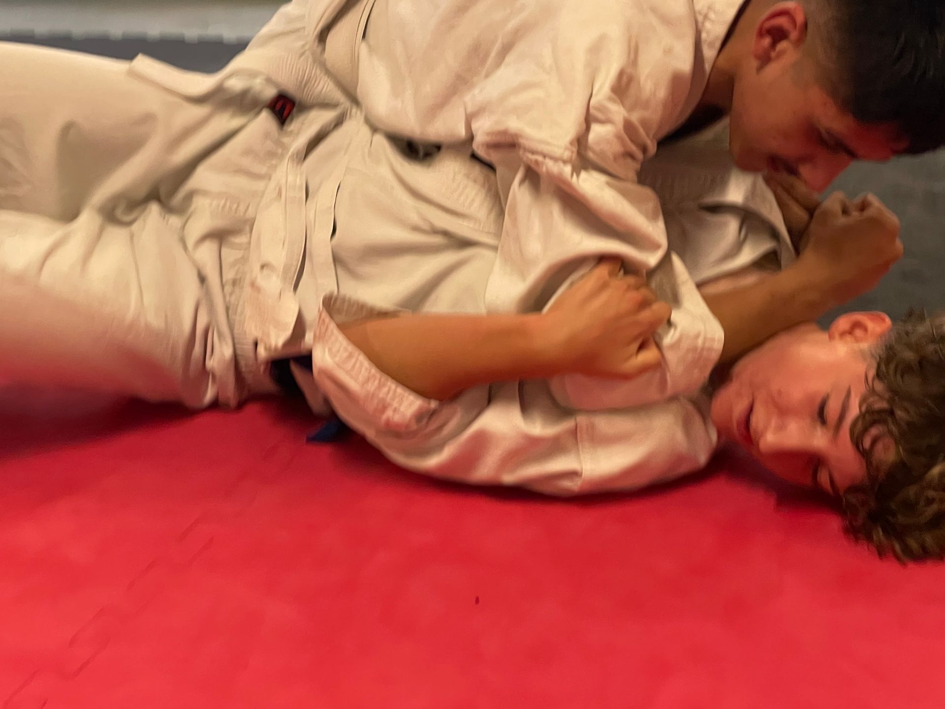 Zwei Karatekas im Sparring demonstrieren einen Roundhousekick. Dies trainiert wie in Kampfsportarten wie Kickboxen, Boxen und Brazilian Jiu  Jitsu Taktik, Timinig und Schnelligkeit.