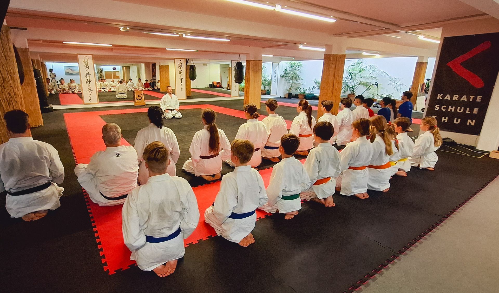 Karateka der Karateschule Thun und Spiez sitzen in Meditationshaltung.