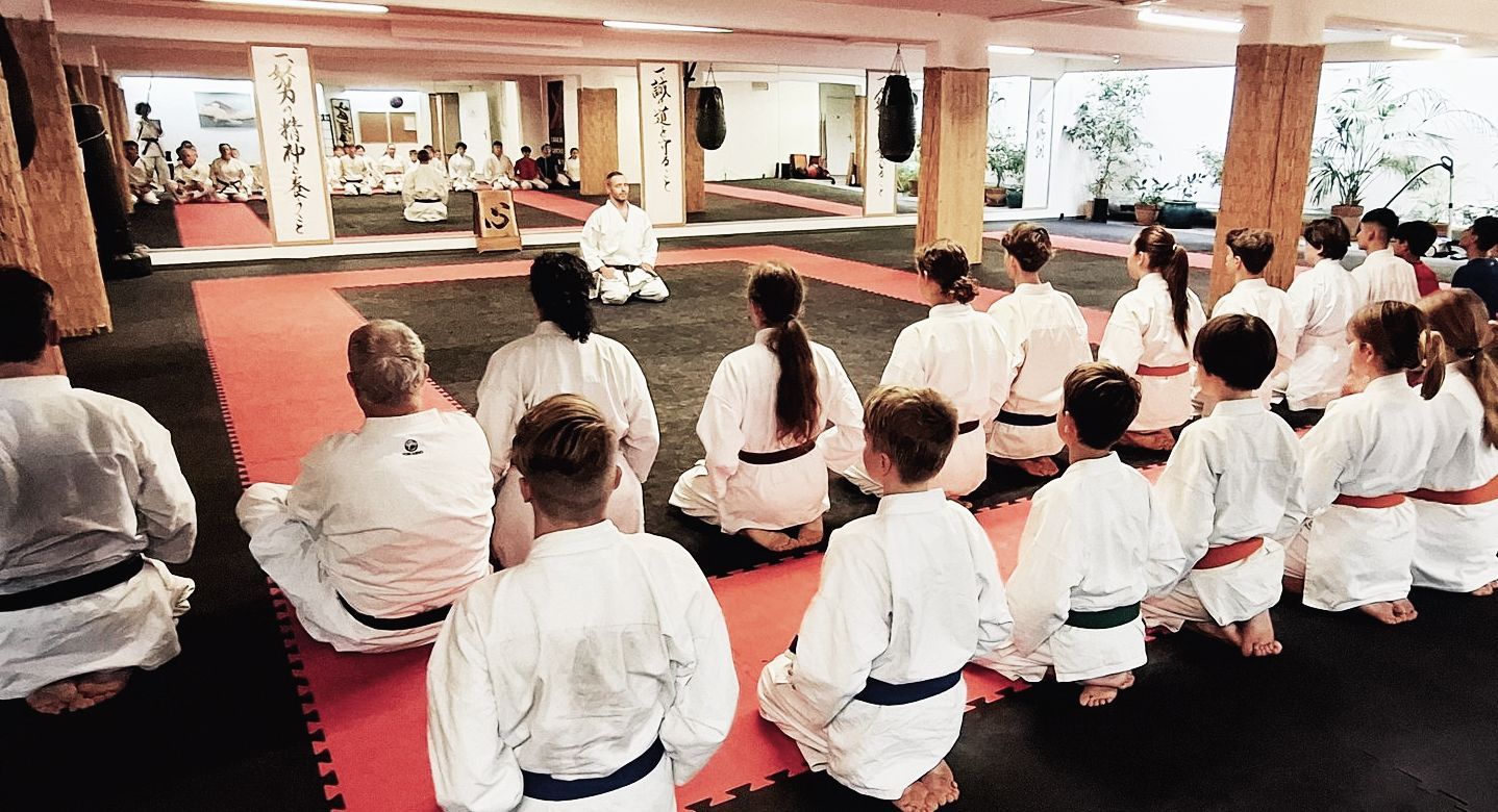 Karate-ka sitzen in Meditationshaltung.