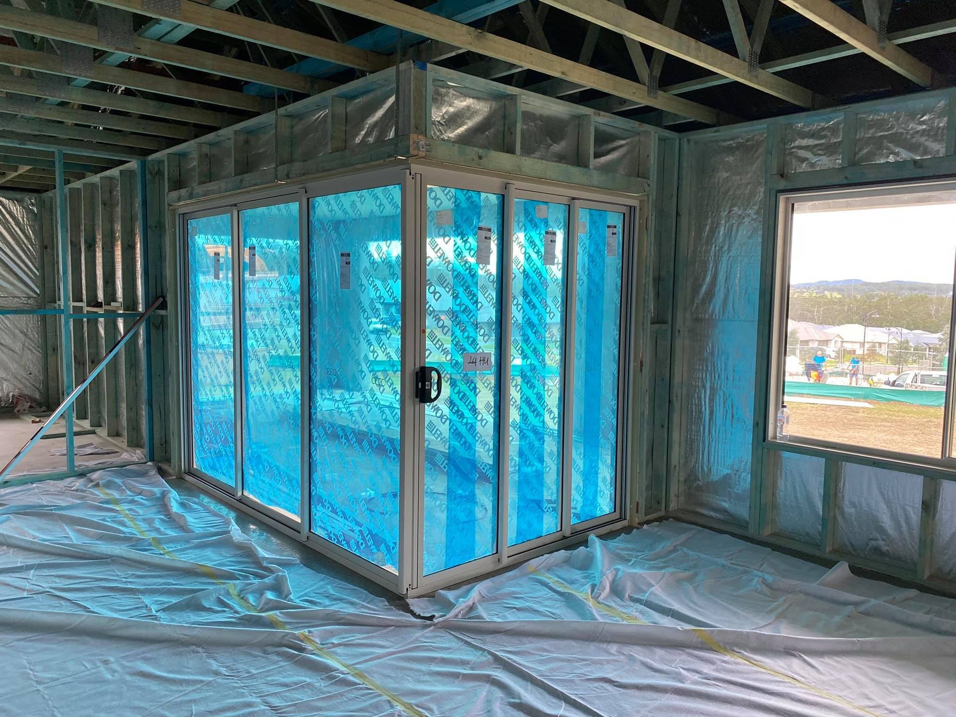 Construction View of A Room with A Blue-Tinted Glass Enclosure and Window — Master Glass & Glazing in Charlestown, NSW