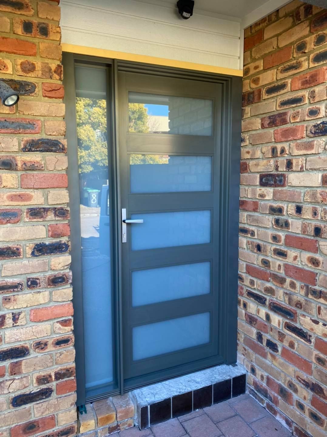 Gray Front Door with Frosted Glass Panels and Sidelight, Set in A Brick Facade — Master Glass & Glazing in Wallsend, NSW