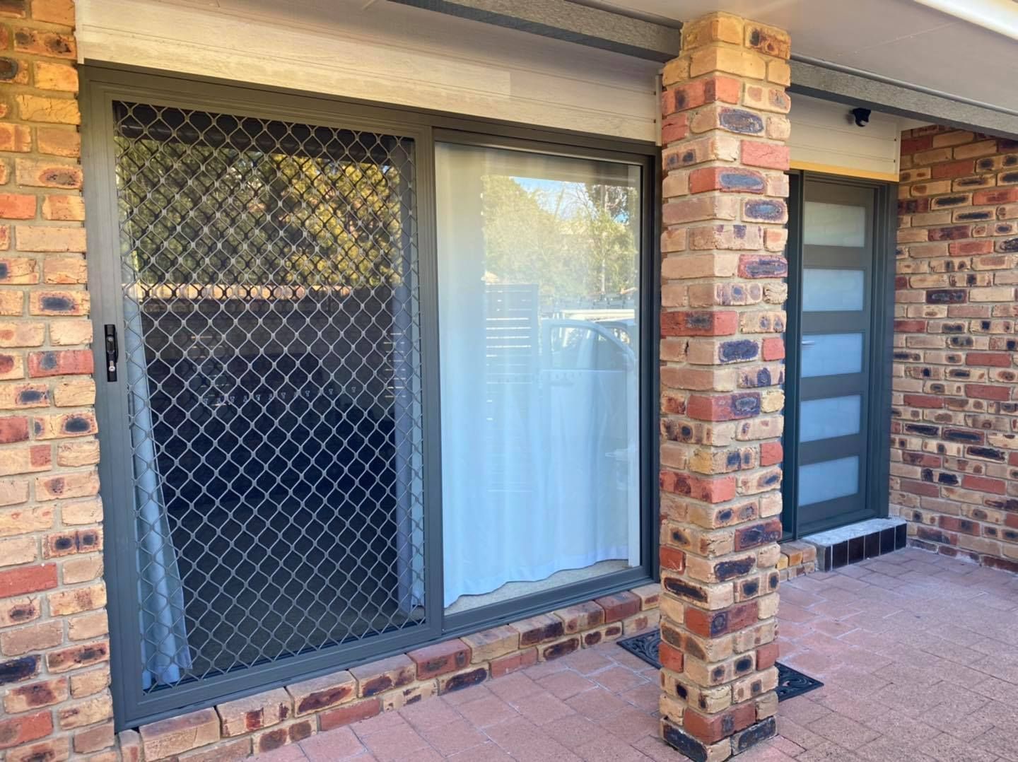 Brick Building Entrance with Security Screen Door, Window, and Modern Front Door — Master Glass & Glazing in Newcastle, NSW