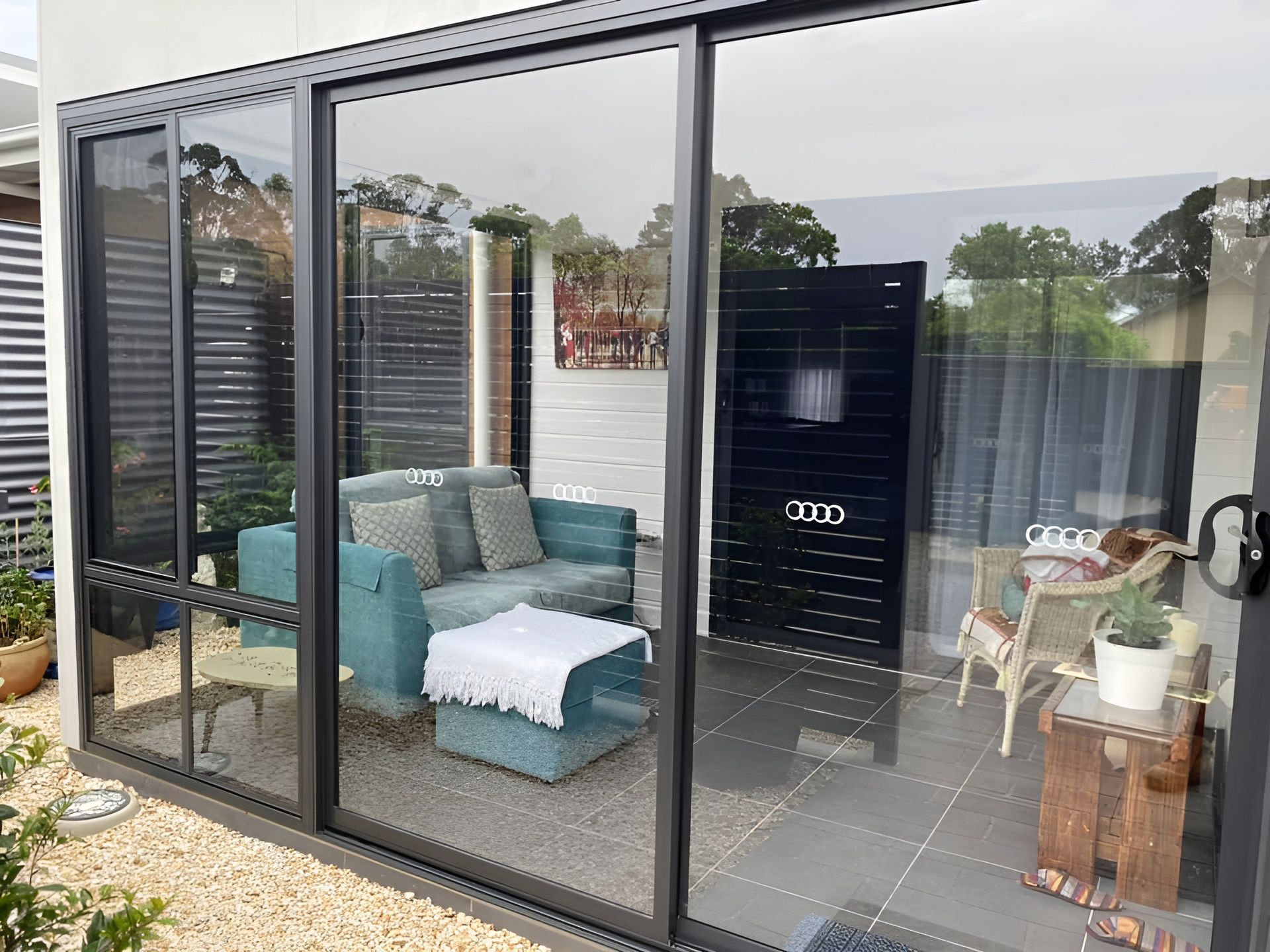 Sliding Glass Doors to A Patio with Turquoise Seating — Master Glass & Glazing in Newcastle, NSW