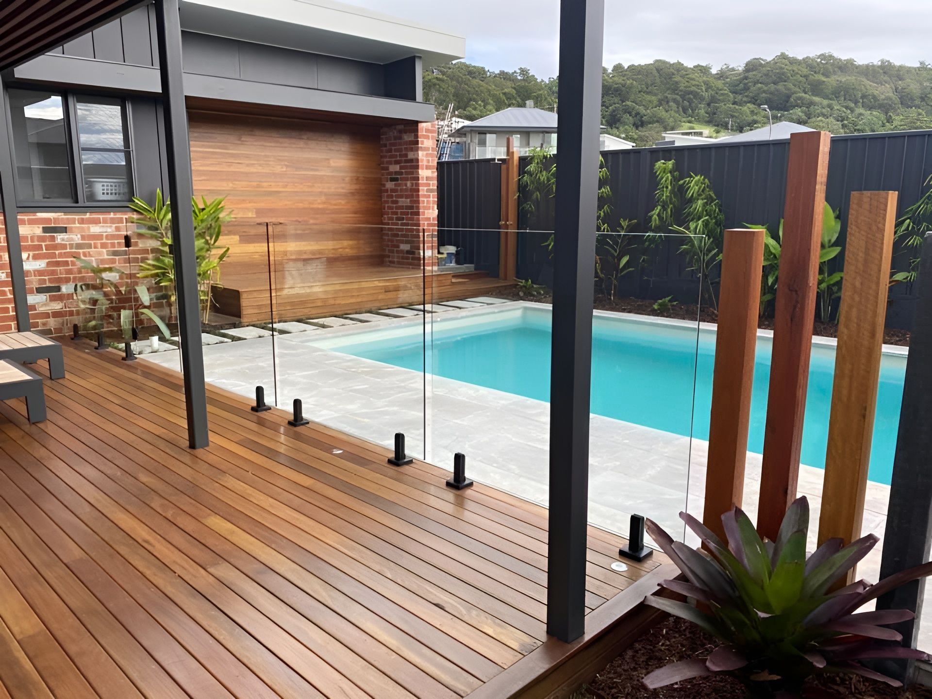 Wooden Deck with Pool, Glass Fencing, and Decorative Wood Posts — Master Glass & Glazing in Newcastle, NSW