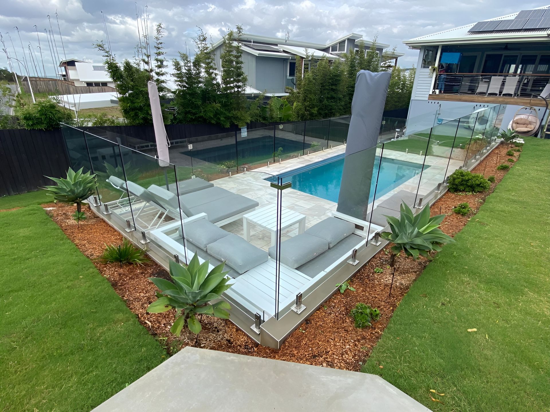 Backyard with Pool, Lounge Chairs, and Landscaping — Master Glass & Glazing in Lake Macquarie, NSW