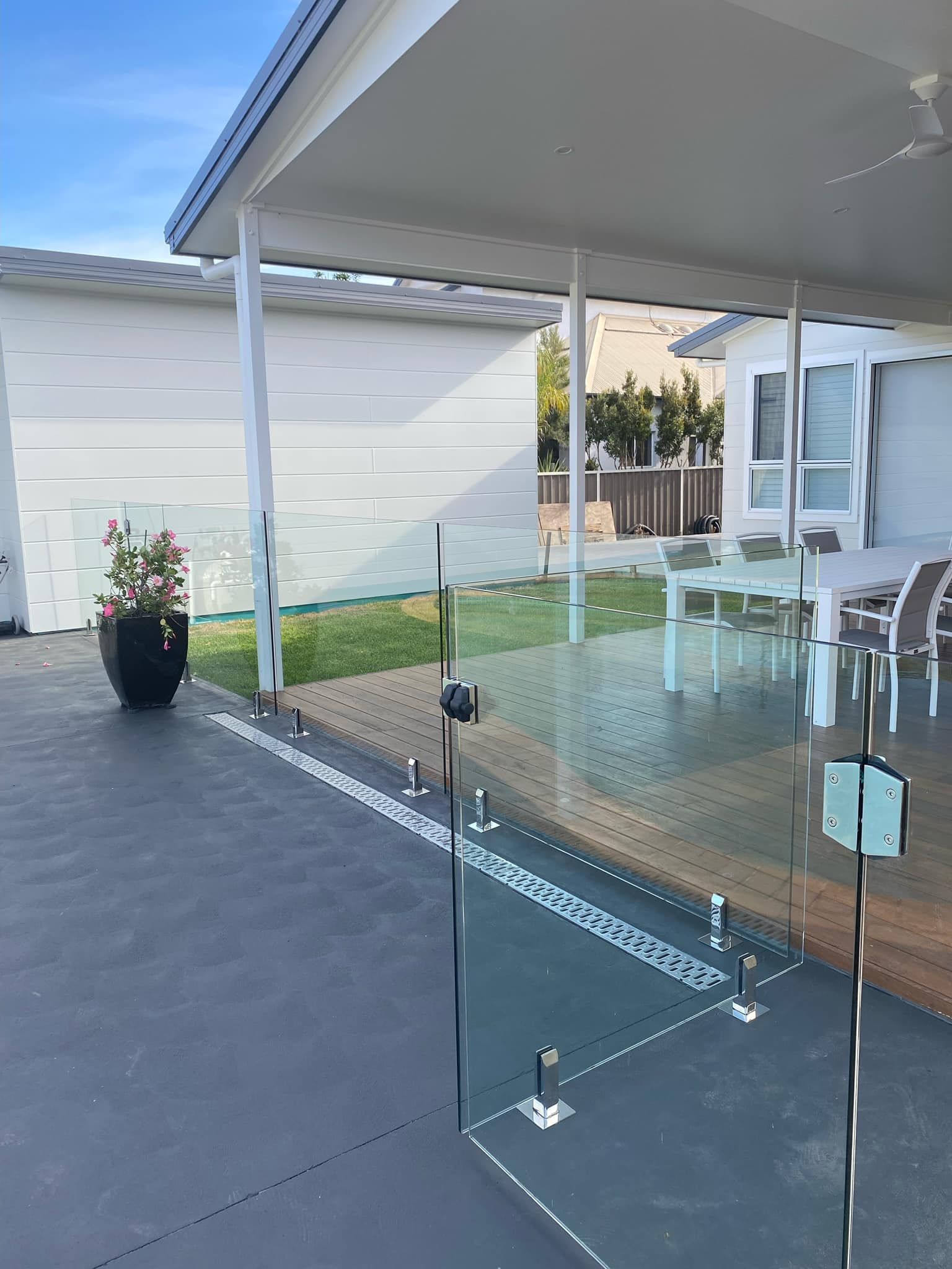 Outdoor Patio with Glass Fencing, a Paved Area, and A White-Roofed Structure — Master Glass & Glazing in Wallsend, NSW