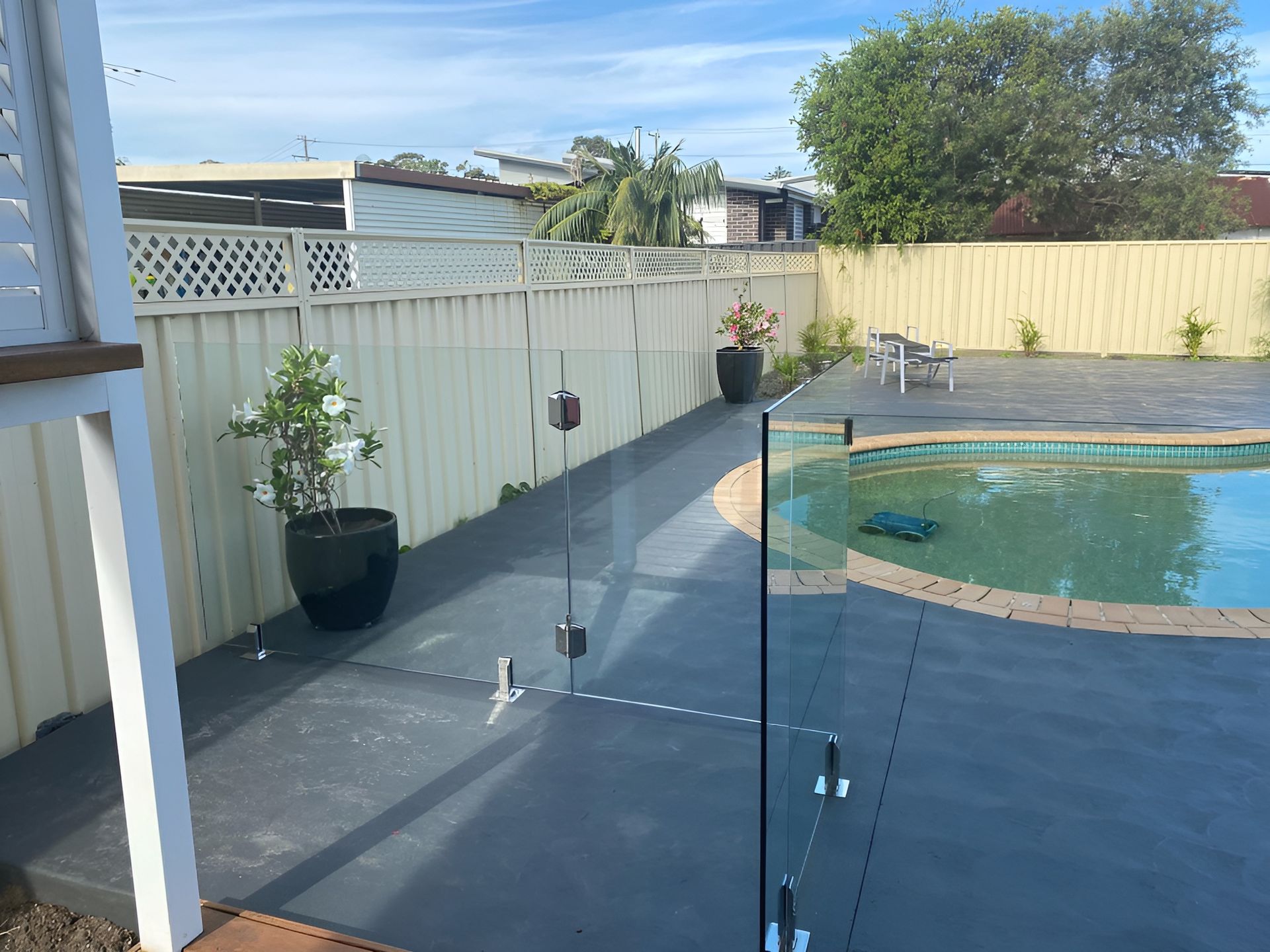 Pool Area with A Glass Fence, Surrounded by A Concrete Patio — Master Glass & Glazing in Warners Bay, NSW