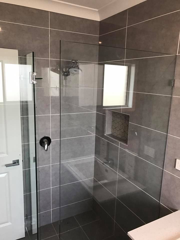 Bathroom with Gray Tiled Walls, Glass Shower Enclosure, and Black Fixtures — Master Glass & Glazing in Mayfield, NSW