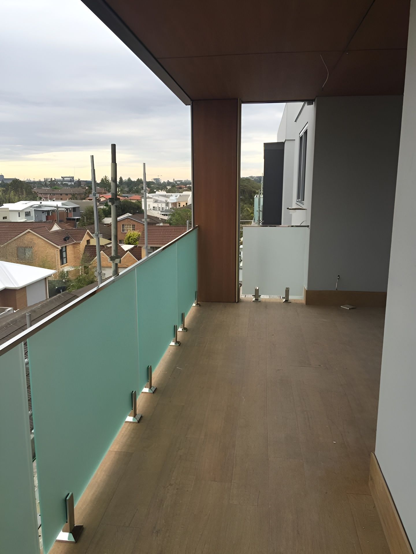 Balcony with Frosted Glass Railing, Brown Flooring — Master Glass & Glazing in Toronto, NSW