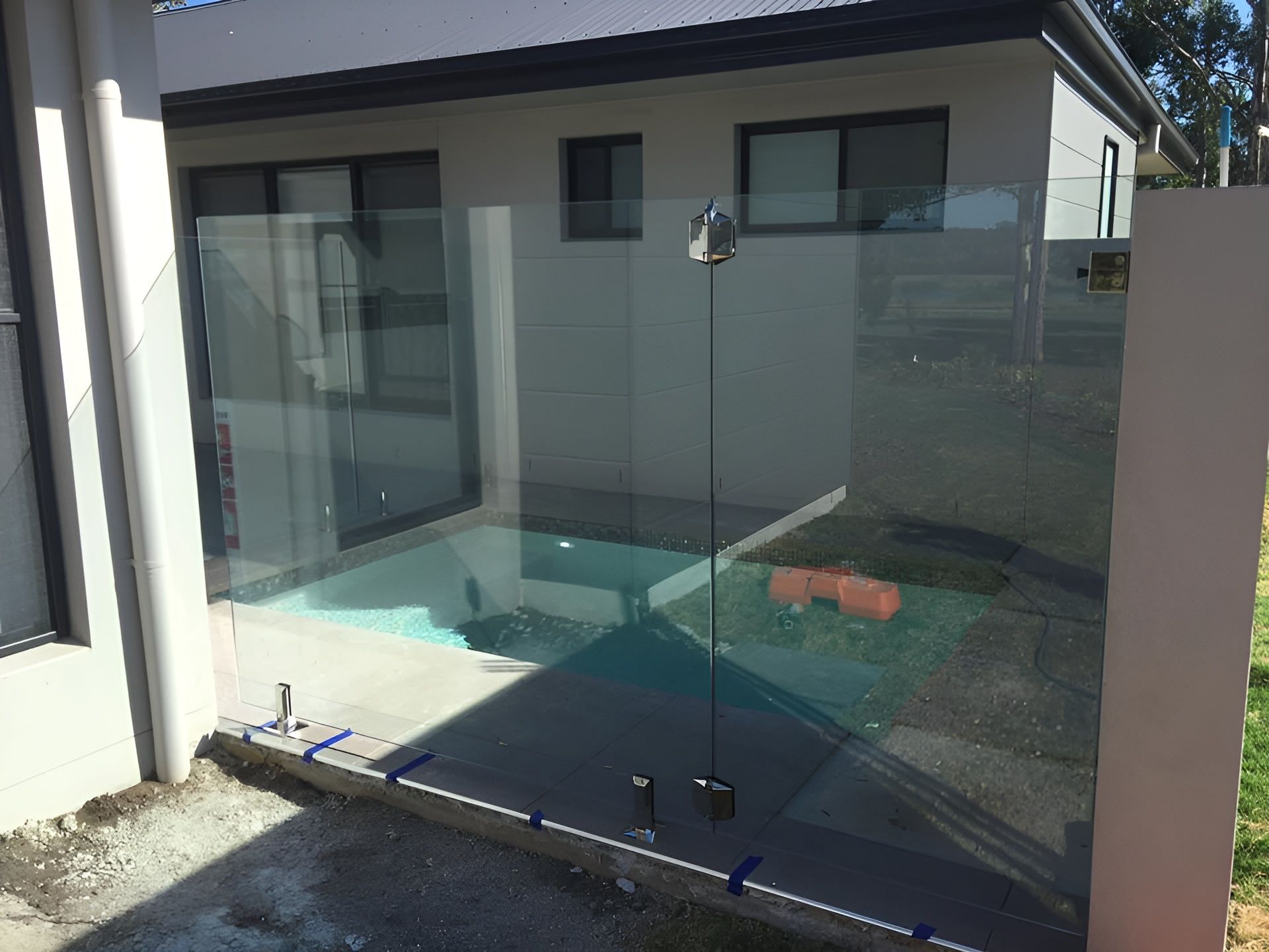 Glass Pool Fence in Front of A House — Master Glass & Glazing in Wallsend, NSW