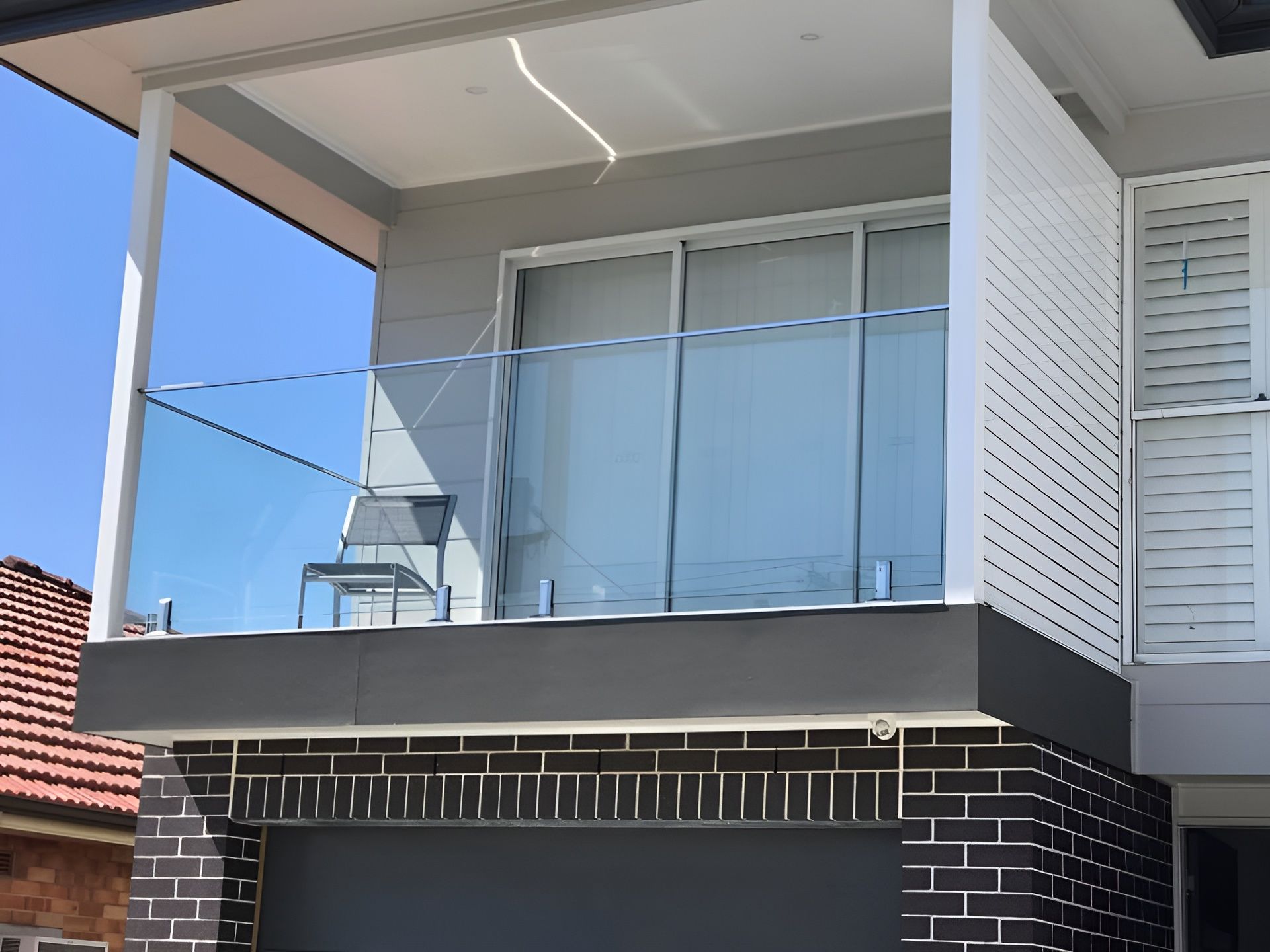 Balcony with Glass Railing on A Modern House with Gray and Brick Facade — Master Glass & Glazing in Wallsend, NSW