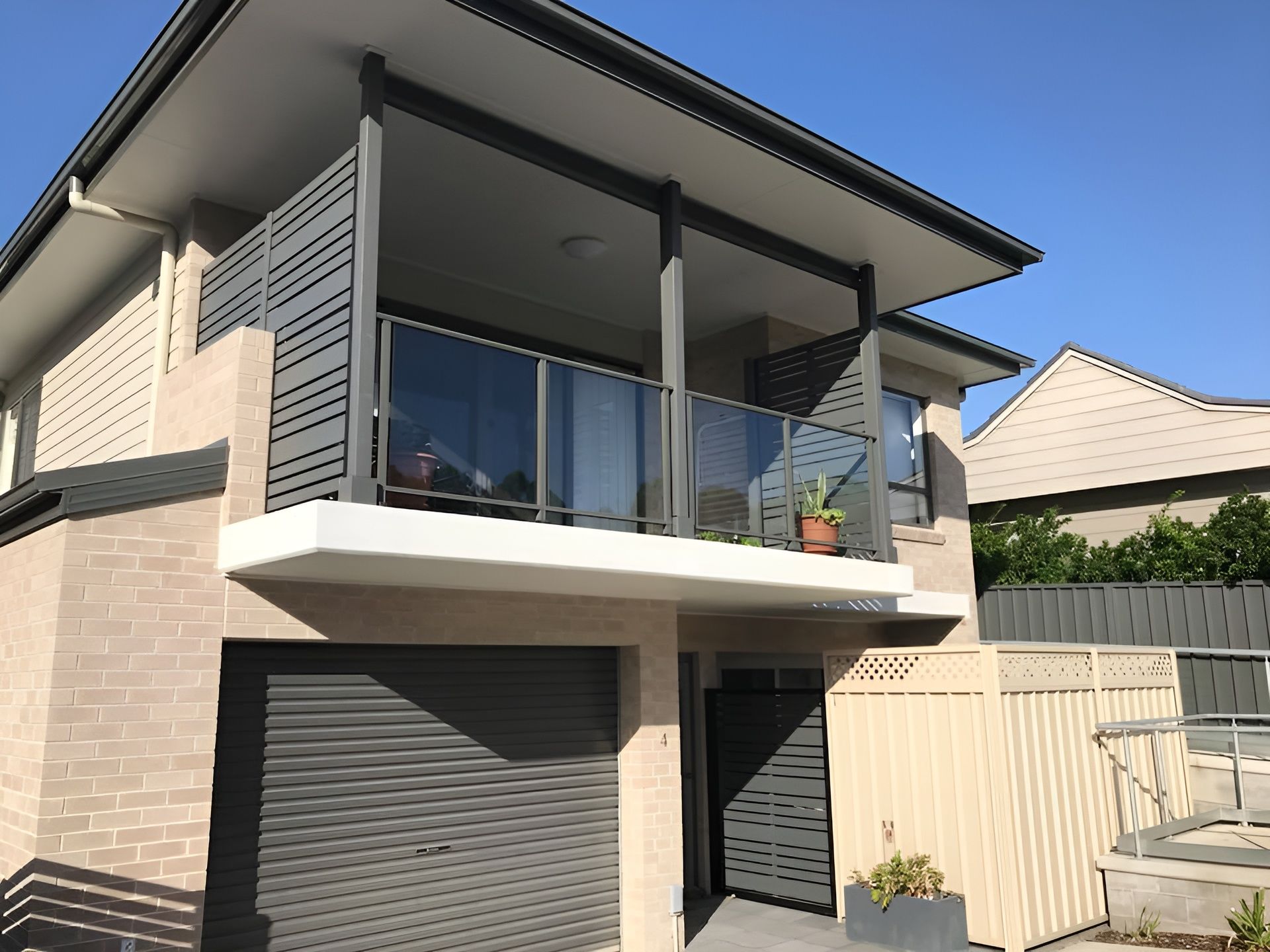 Two-Story House with A Balcony Featuring Glass and Gray Railings — Master Glass & Glazing in Charlestown, NSW