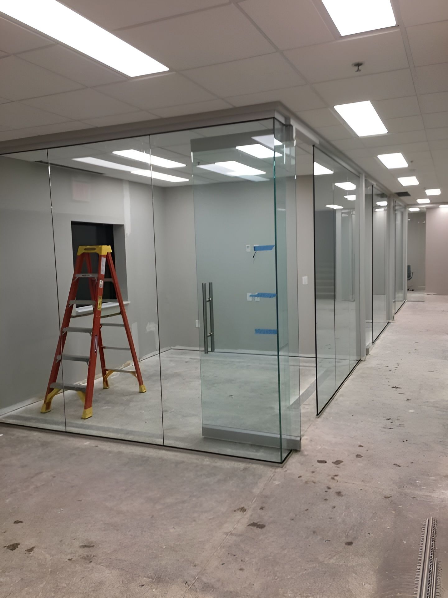 Office Space with Glass Walls, Unfinished Concrete Floor, and A Ladder — Master Glass & Glazing in Newcastle, NSW