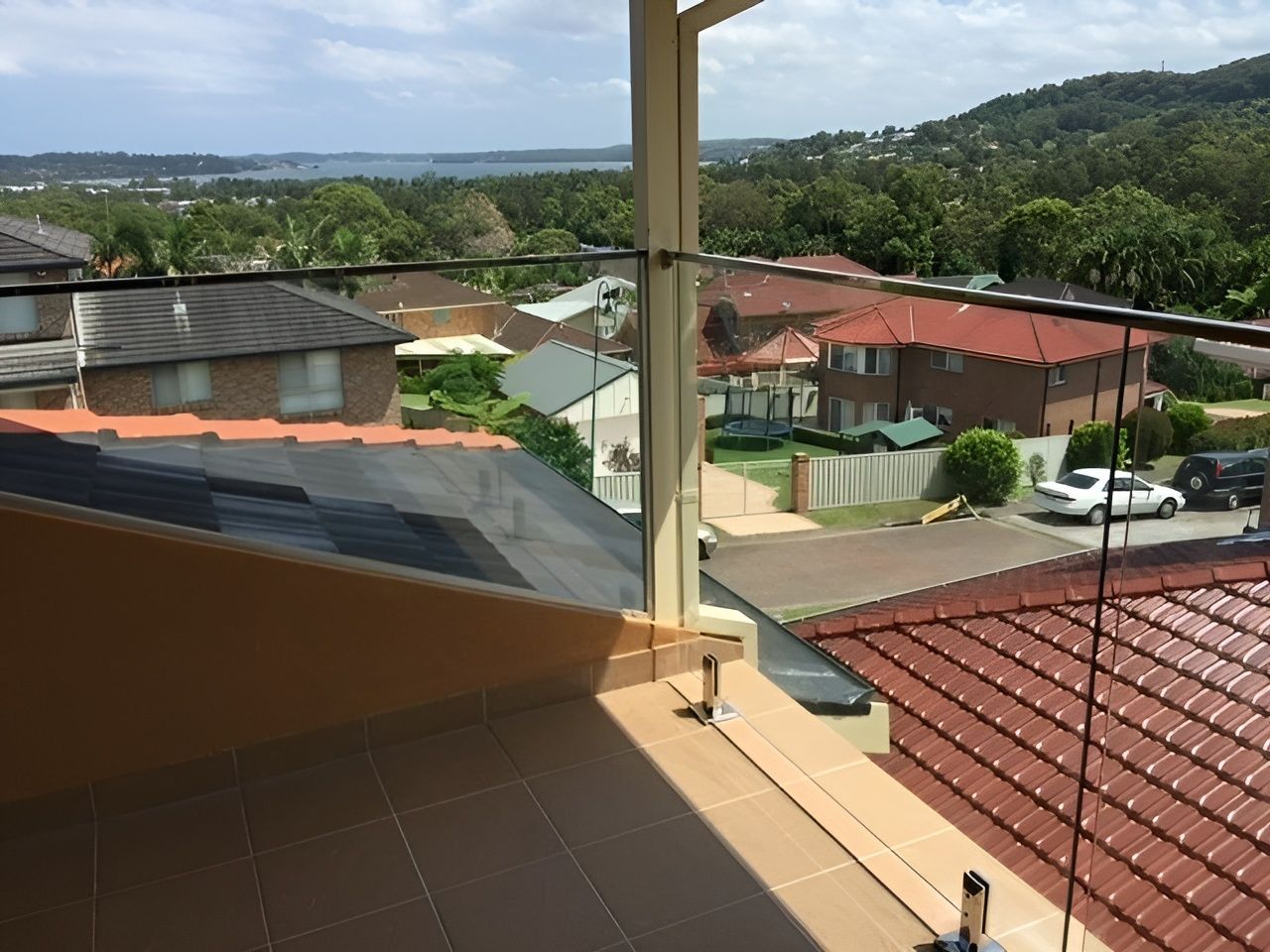 View from A Balcony With Glass Balustrades Overlooking a Residential Neighborhood — Master Glass & Glazing in Newcastle, NSW