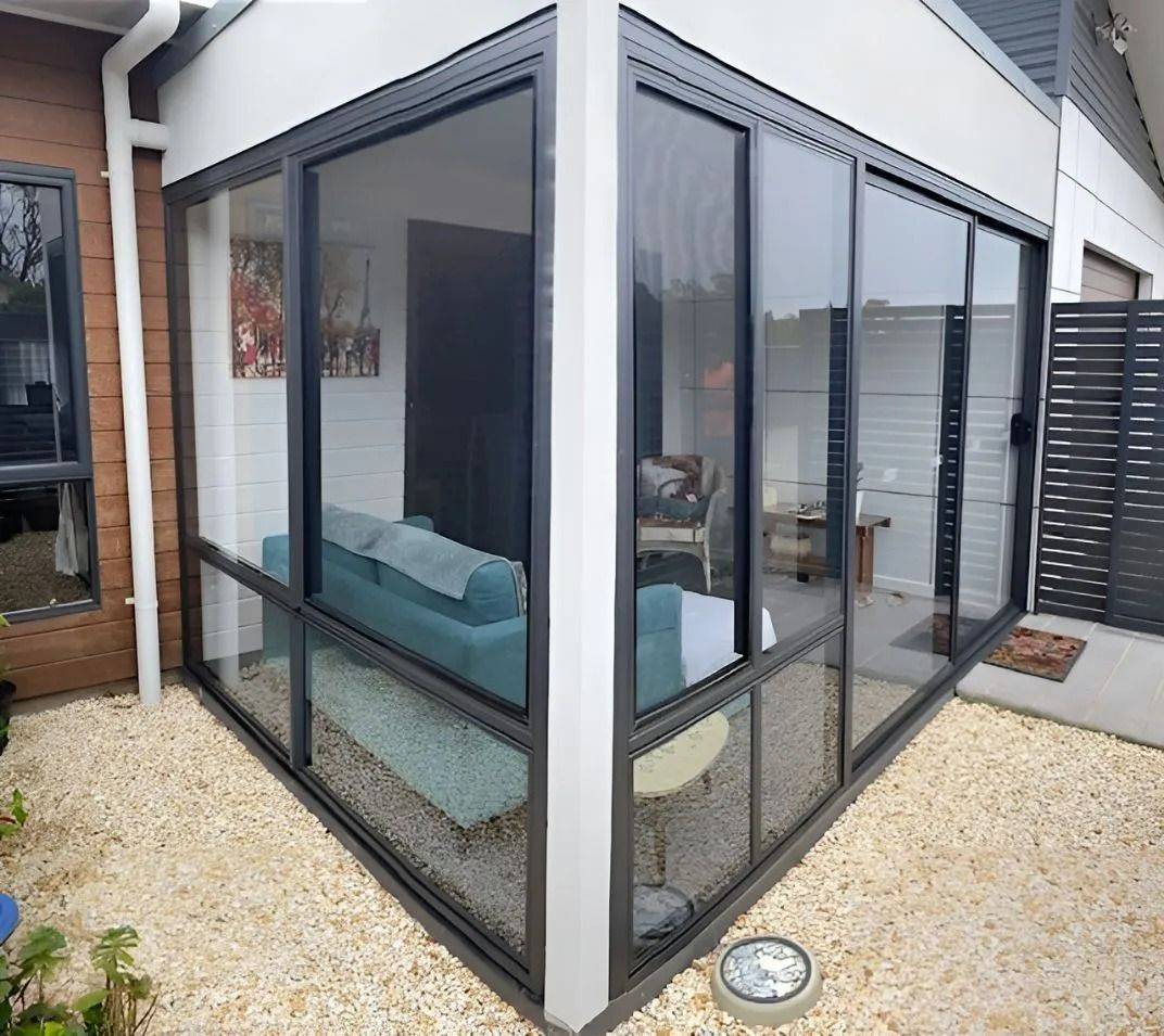 Glass-Walled Room with Black Frames. Turquoise Sofa Visible Inside — Master Glass & Glazing in Newcastle, NSW