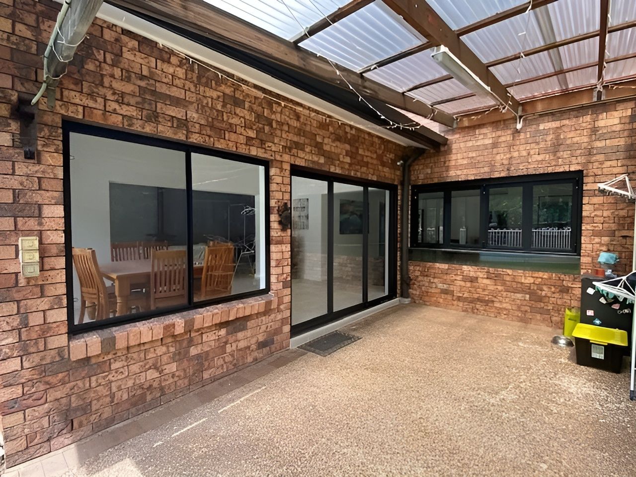 Exterior View of A Brick Patio with Black-Framed Sliding Glass Doors — Master Glass & Glazing in Newcastle, NSW
