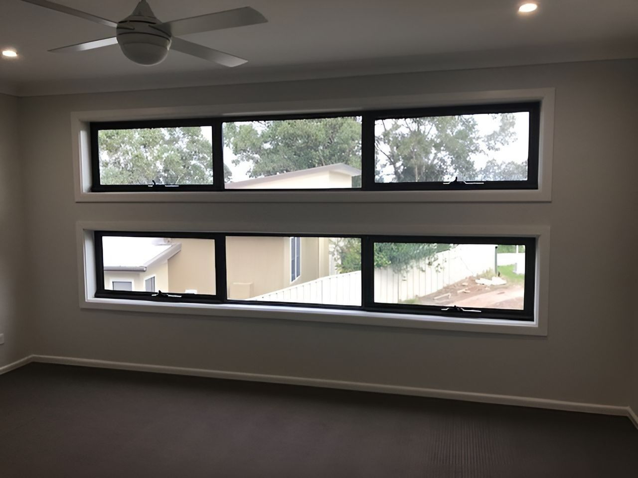 Two Rows of Rectangular Windows in A Room with A Ceiling Fan, Looking Outside — Master Glass & Glazing in Newcastle, NSW