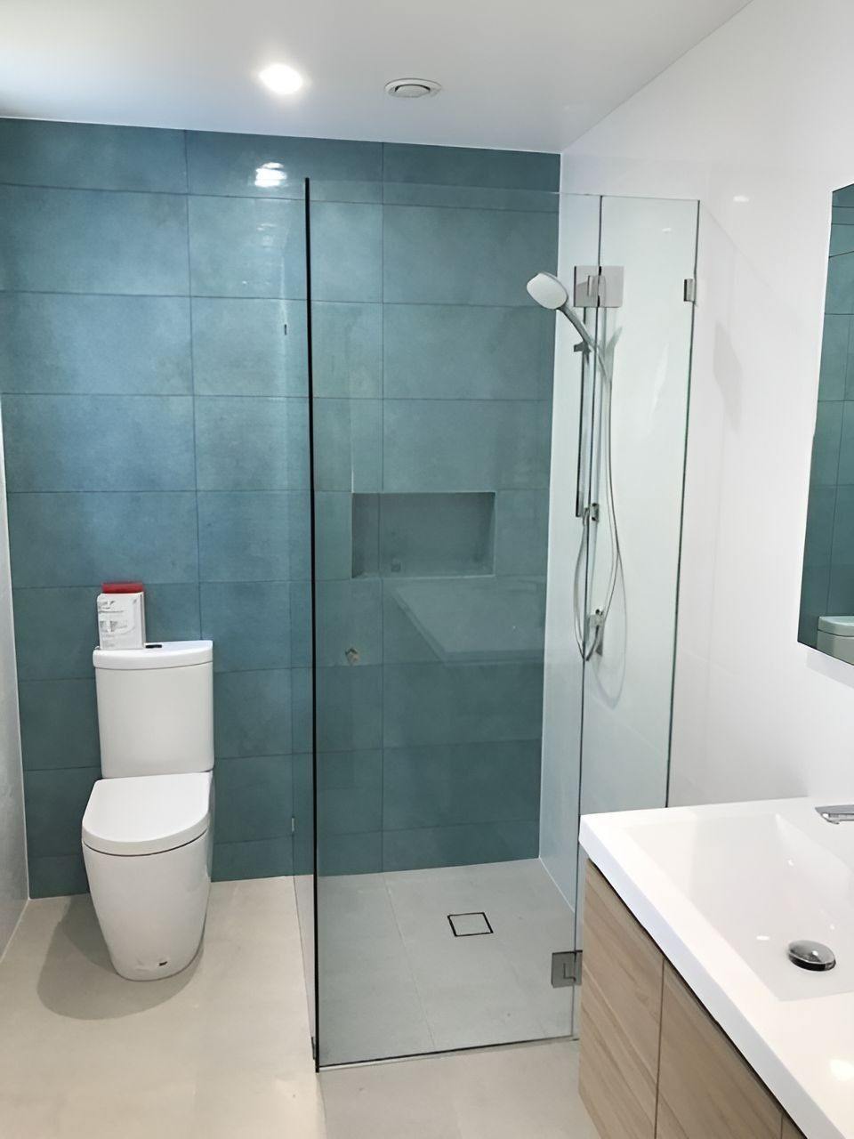 Modern Bathroom with Teal Tiled Wall, Glass Shower, Toilet, and Wooden Vanity — Master Glass & Glazing in Newcastle, NSW