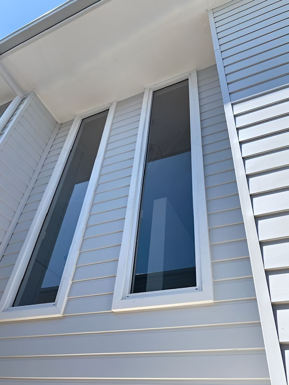 Two Tall, Narrow Windows in A Light Gray House, Framed in White — Master Glass & Glazing in Newcastle, NSW