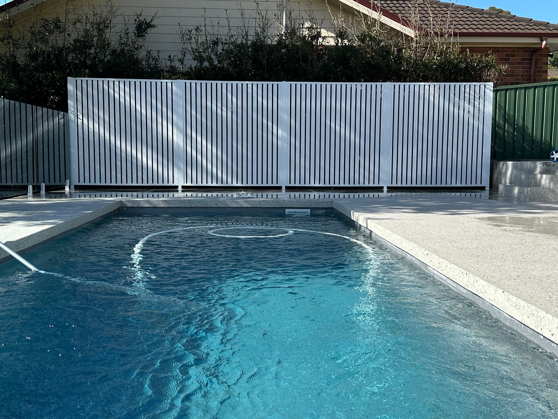 Pool with Blue Water and Modern, White Slatted Fence in Backyard — Master Glass & Glazing in Newcastle, NSW