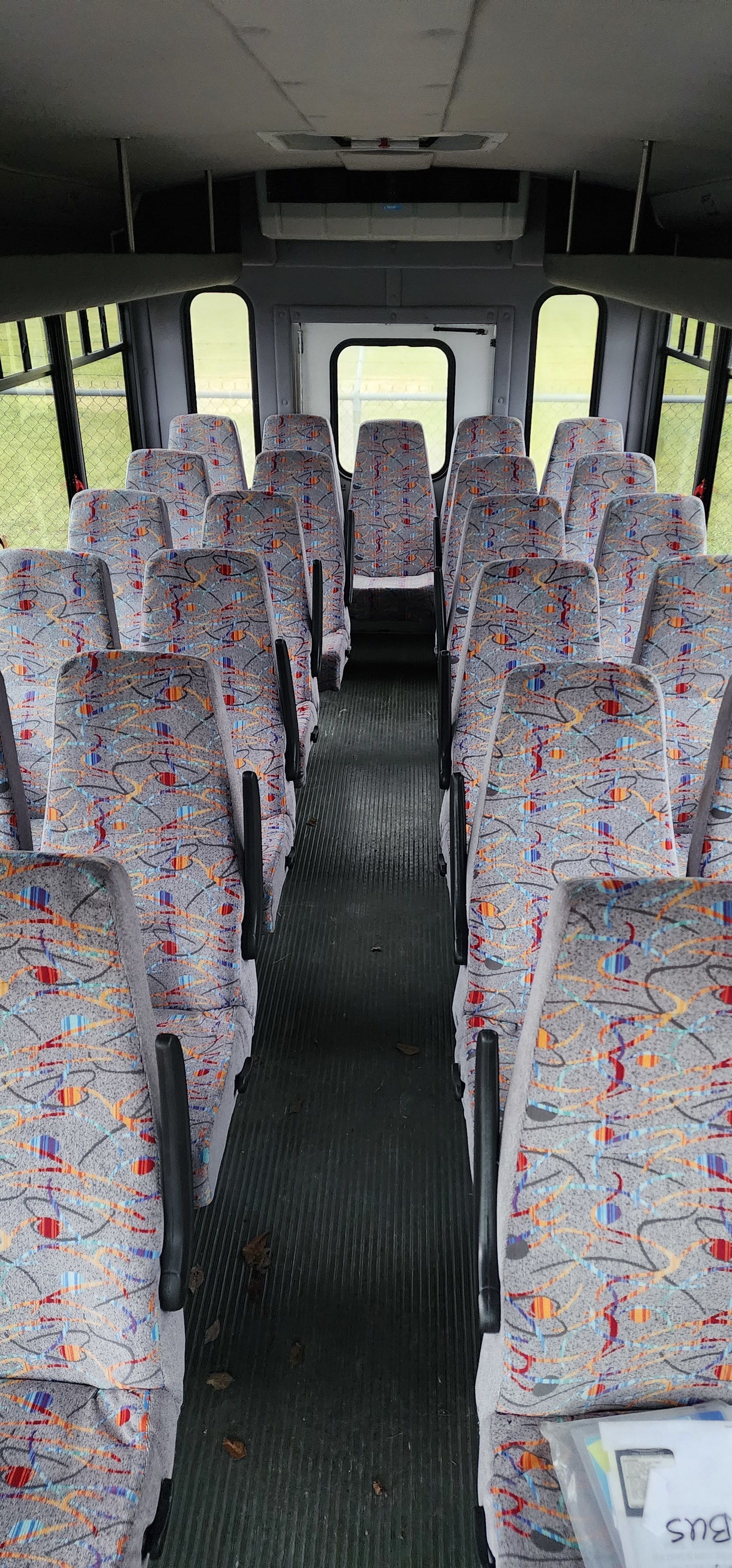 The inside of a bus with lots of colorful seats.