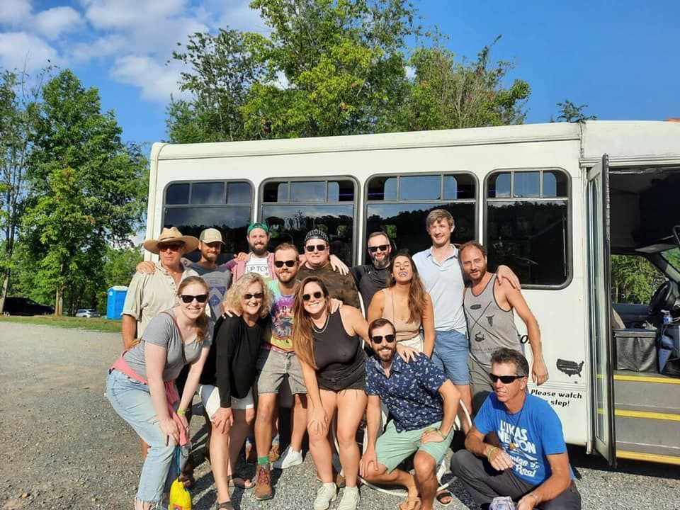 A group of people are posing for a picture in front of a bus.