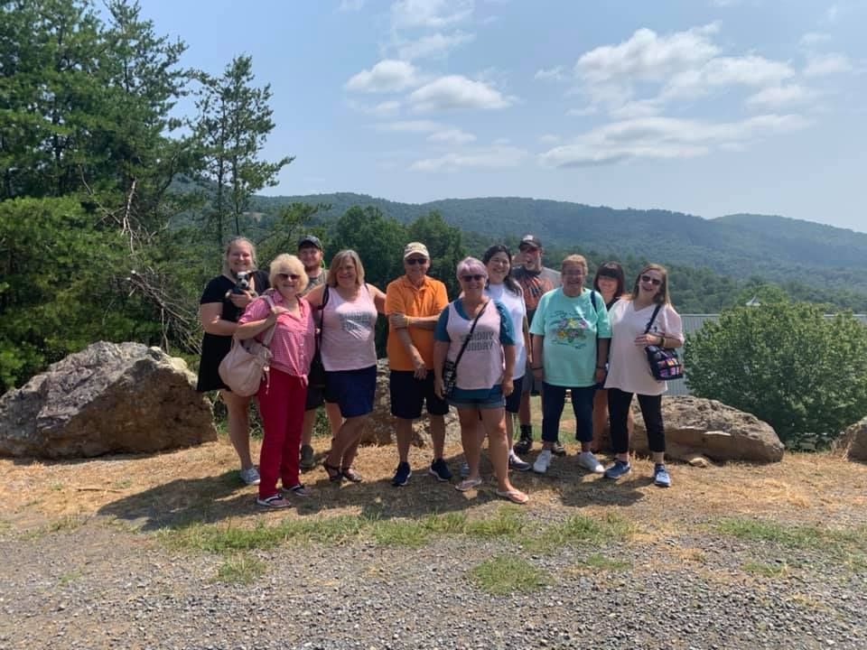 A group of people are posing for a picture on top of a hill.