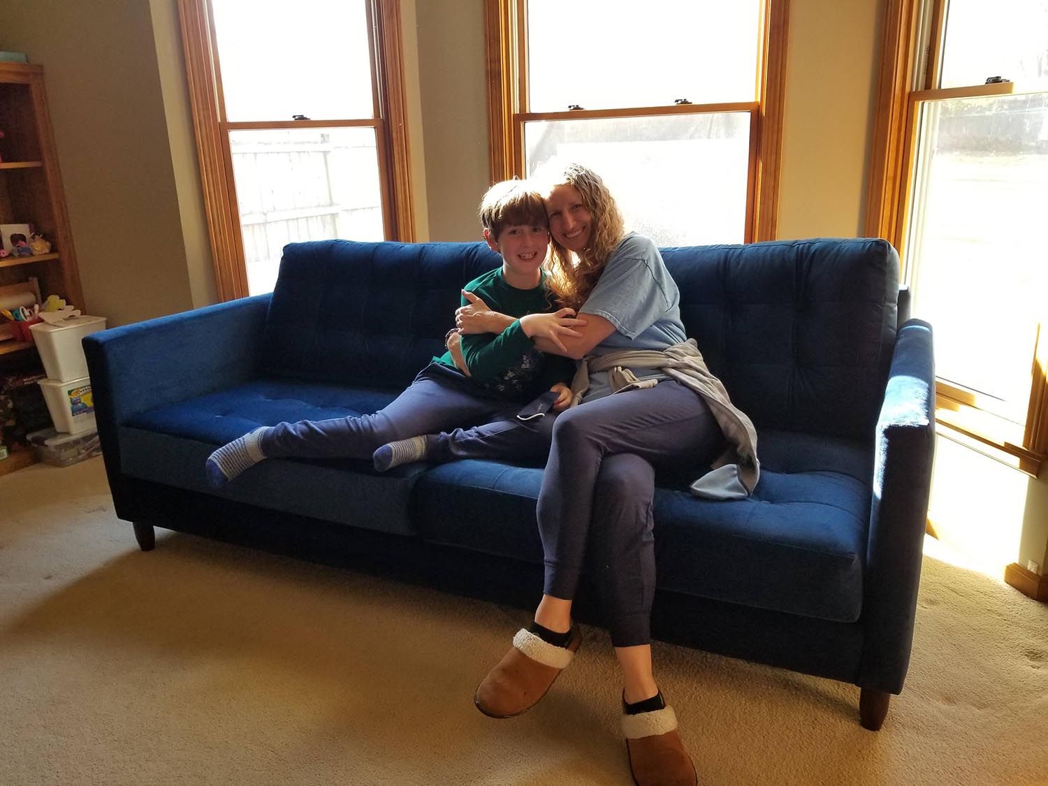 Mother and son sitting on their new sofa purchased from Eagles' Rest Natural Mattresses and Furniture in Lawrence, Kansas.