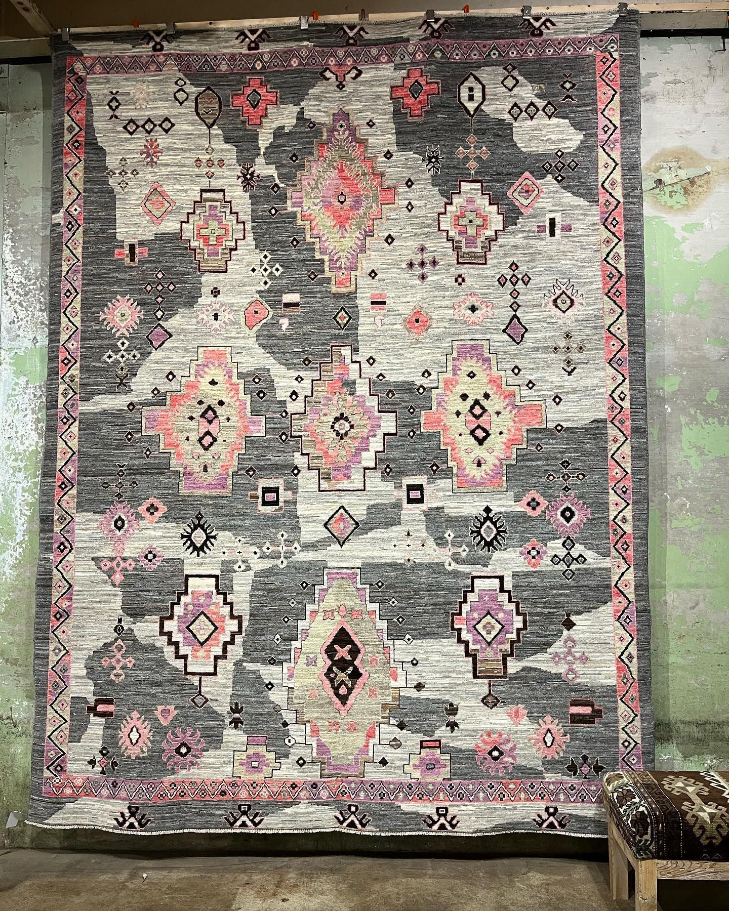 Gray, pink, and white rug hanging on a wall at Eagles' Rest Natural Mattresses and Furniture inLawrence, Kansas.