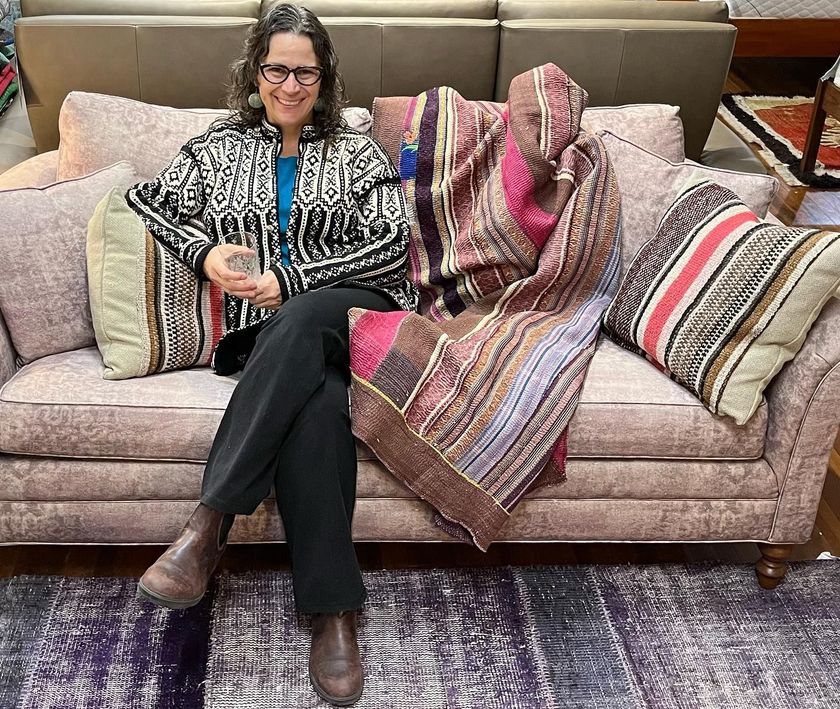 Diane Gercke sitting on a beautiful couch for sale at Eagles' Rest Natural Mattresses and Furniture.