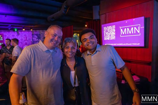 Person wearing headphones, preparing to record audio in a home studio, with microphone and computer.