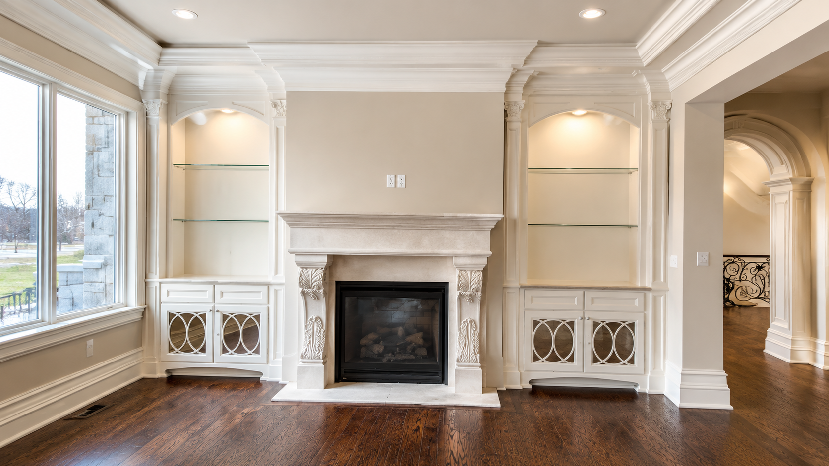 Elegant living room with white fireplace, built-in shelves, and dark hardwood floors