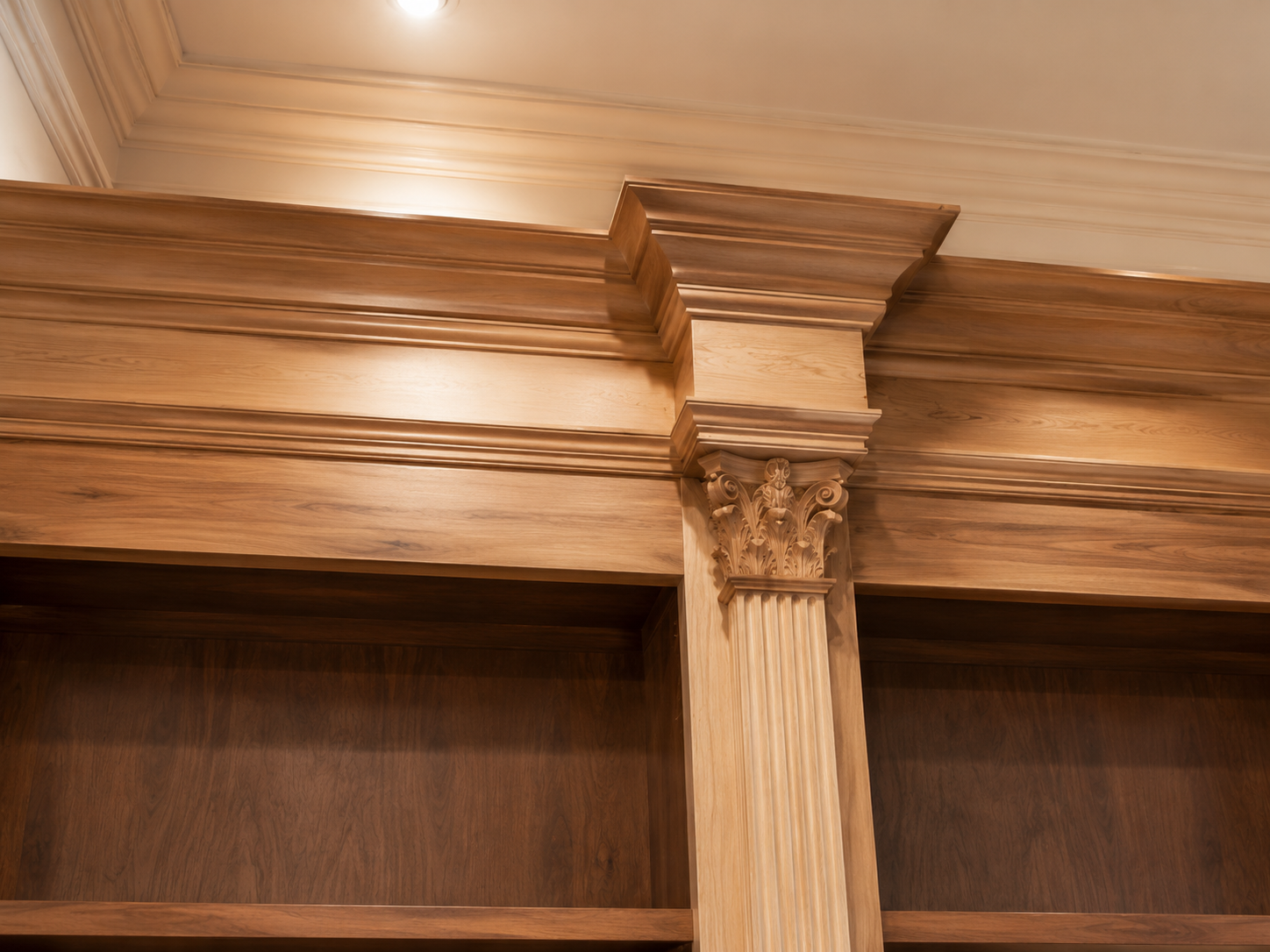 Wooden cabinet crown molding with a carved center column in warm brown tones