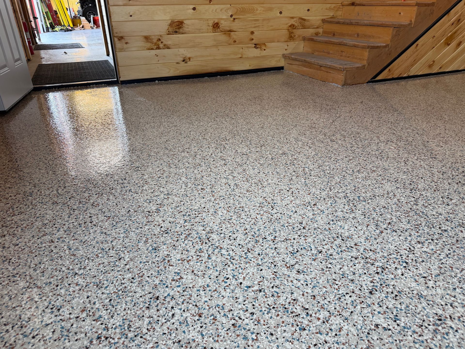 Living room with rocking chair, armchair, and large window overlooking ocean and palm trees.