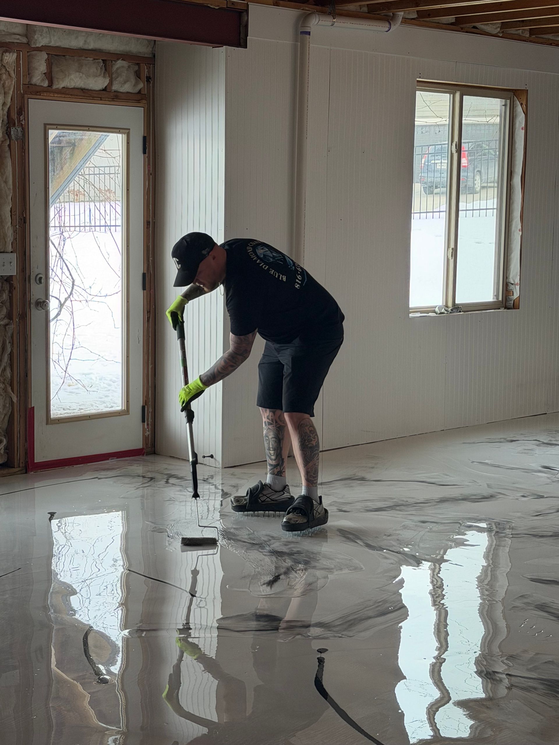Round tables with stools in a dimly lit cafe, sunlight streaming in.