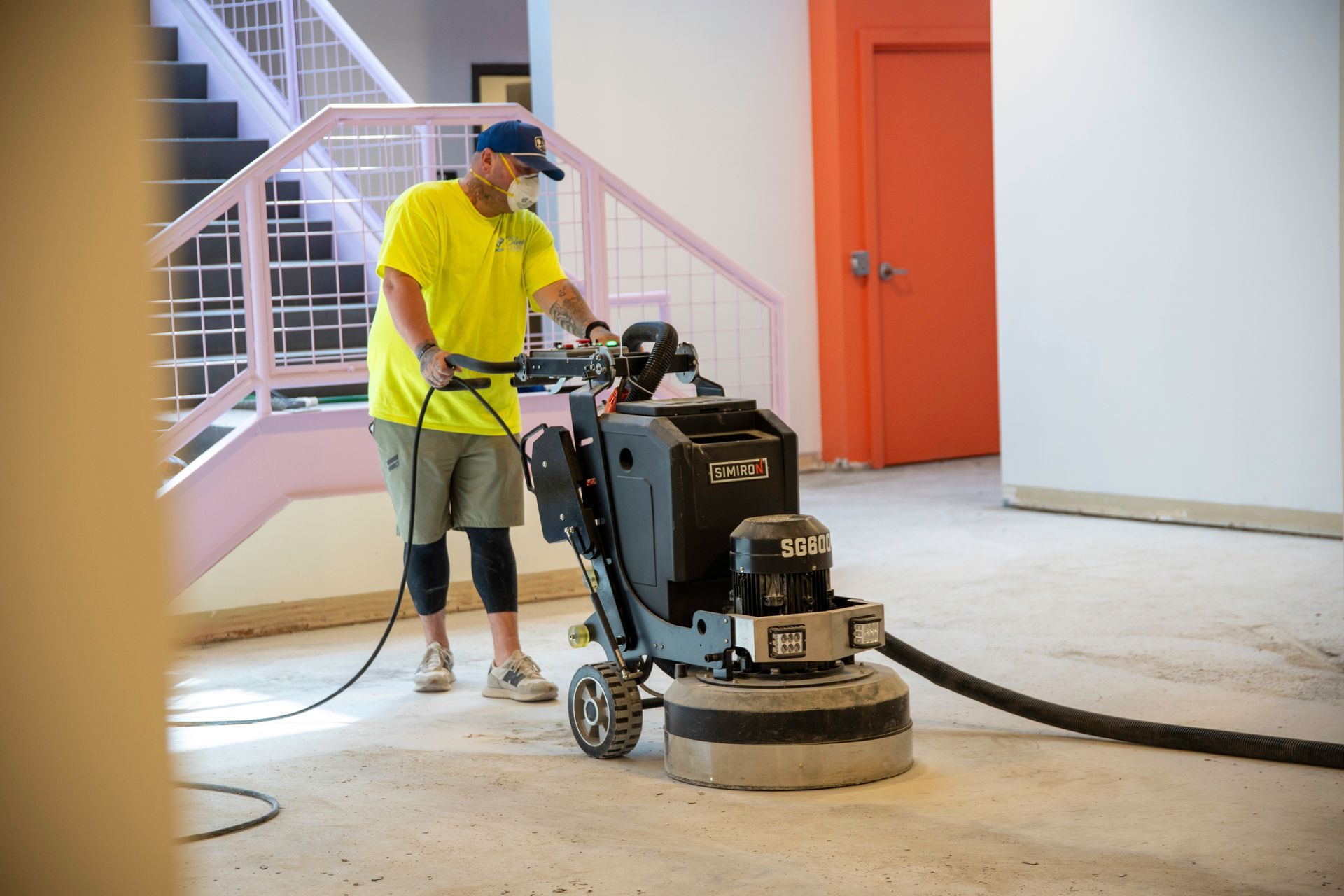 Warehouse interior with forklifts, workbenches, and tools. Red and green equipment, grey floor.