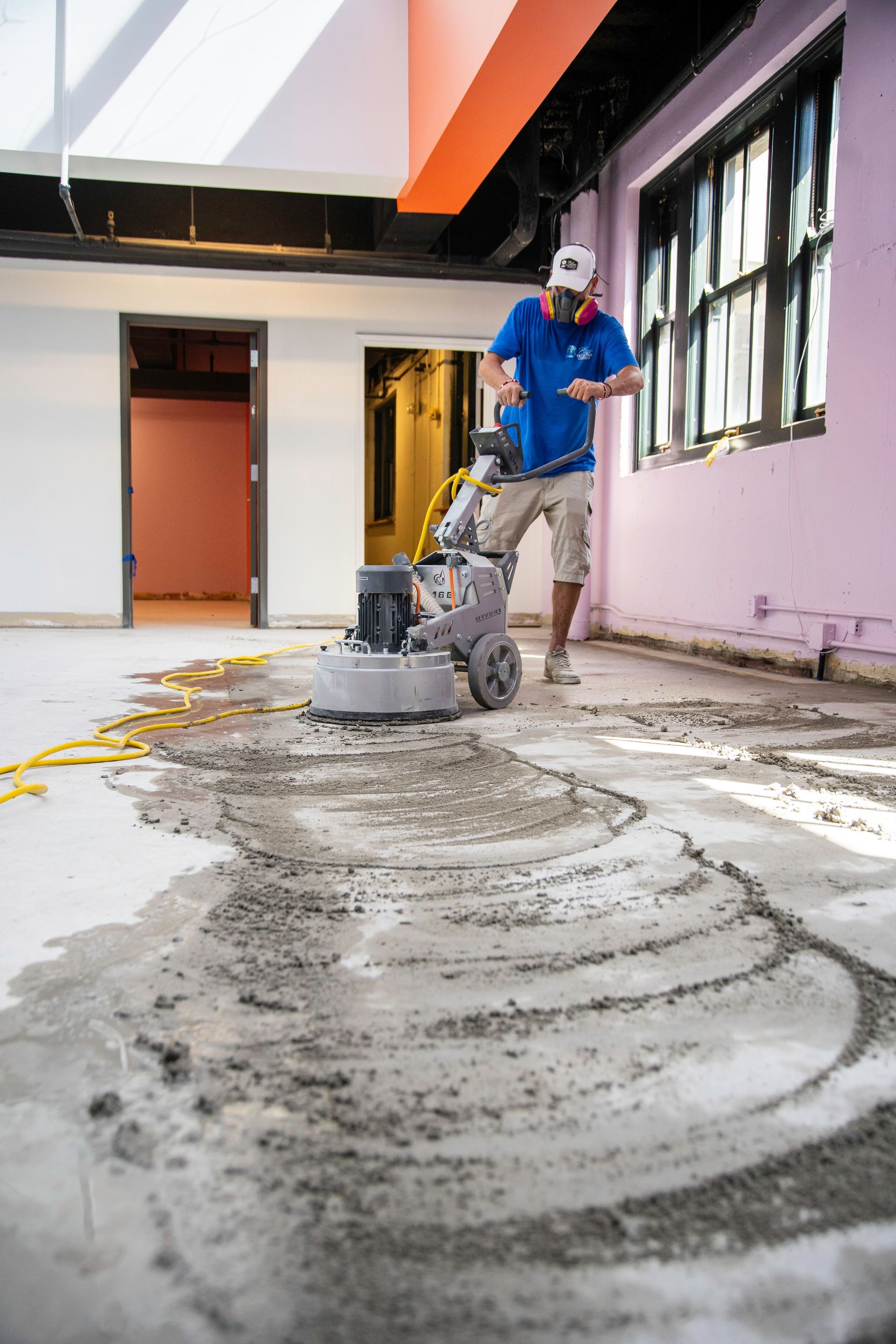 Yellow-toned clothing store interior with clothing racks and shelves.