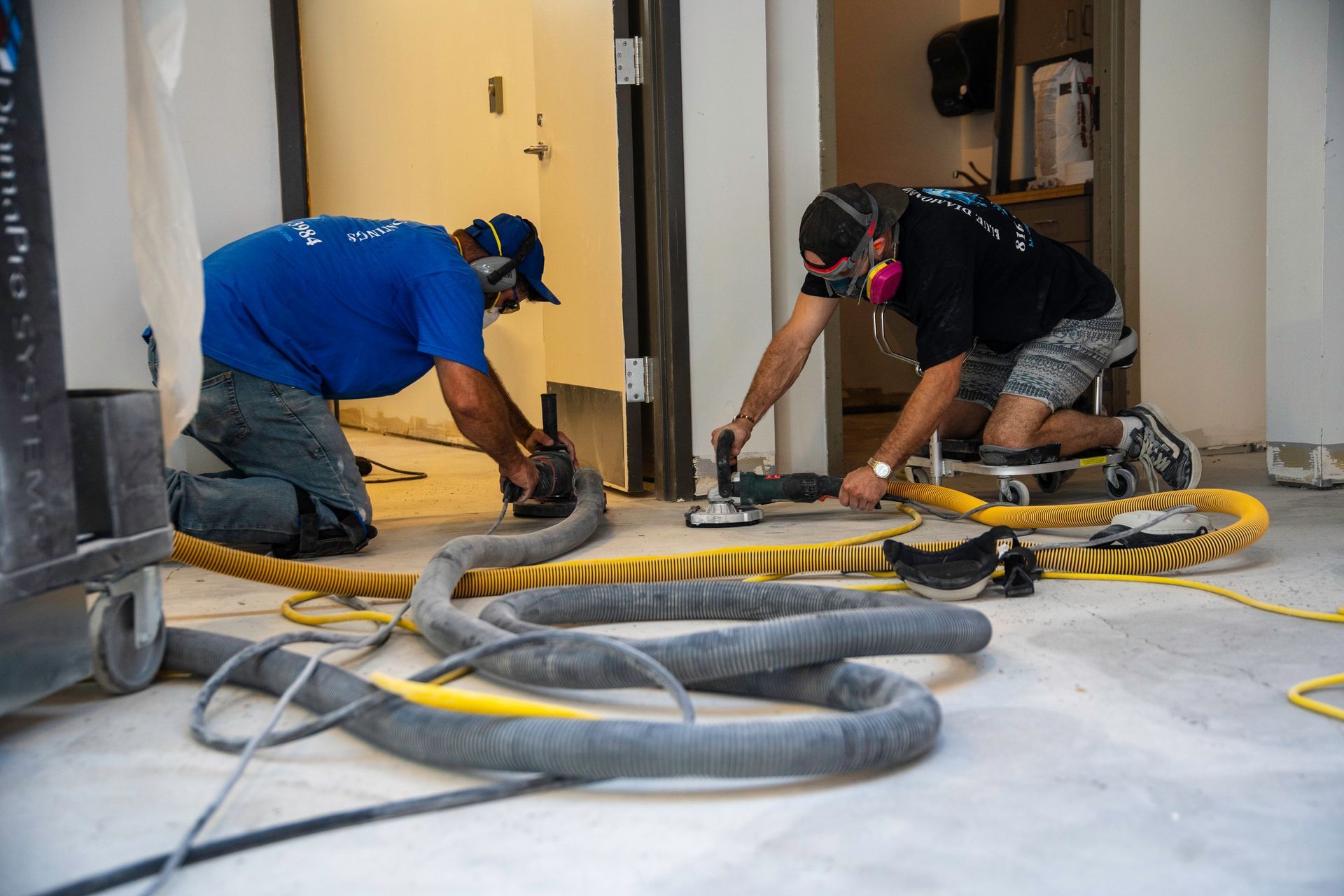 Warehouse interior with shelving, work tables, and concrete floor under bright lights.