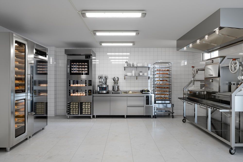 Modern commercial food equipment in a professional kitchen with bakery tools and fresh baked goods.