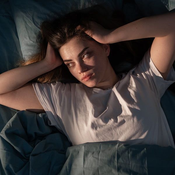 A woman with insomnia is lying in bed awake