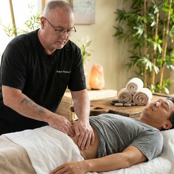 Robert Pineau, Licensed Massage Therapist, gives an Asian patient a Visceral Manipulation Massage in his Ronkonkoma, NY, massage office.